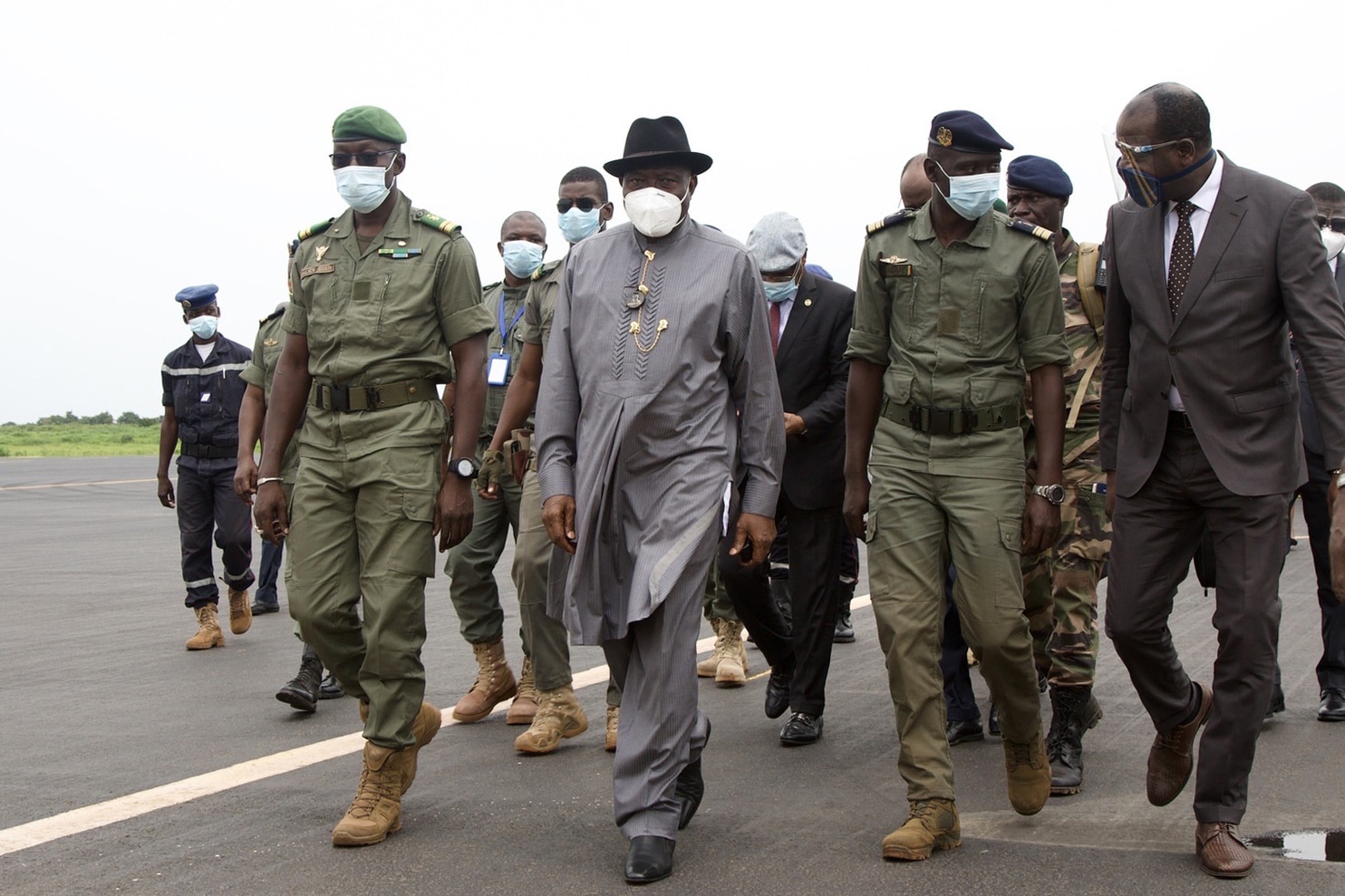 L'ancien président nigérian Goodluck Jonathan (2L) se promène à l'aéroport international de Bamako à son arrivée le 22 août 2020 à côté de Malick Diaw (à gauche), le vice-président du CNSP (Comité national pour le salut du peuple). - Une délégation de dirigeants ouest-africains dirigée par l'ancien président nigérian Goodluck Jonathan est arrivée dans la capitale malienne Bamako le 22 août pour une mission de rétablissement de l'ordre après un coup d'État militaire. (Photo par ANNIE RISEMBERG / AFP)