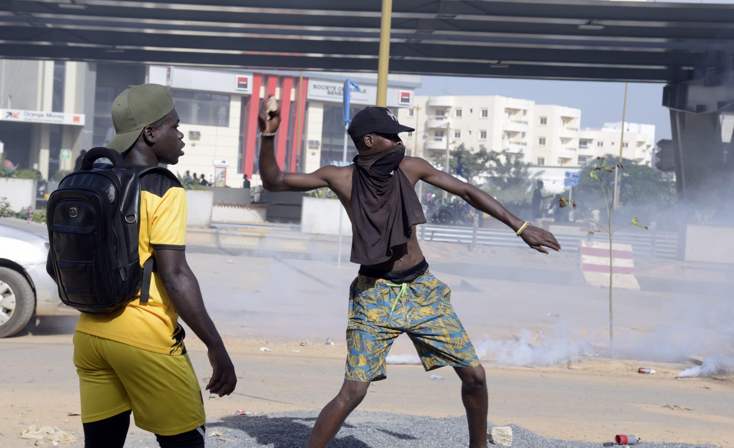 Un manifestant jette une pierre lors d'une manifestation de membres de l'opposition guinéenne, dans une rue menant à l'ambassade de Guinée à Dakar, le 21 octobre 2020. - Alors que les tensions sont déjà vives, le principal chef de l'opposition guinéenne Cellou Dalein Diallo a déclaré le 19 octobre sa victoire à l'élection - avant l'annonce des résultats officiels, qui sont attendus cette semaine. Les partisans de l'opposition sont profondément méfiants quant à l'équité du scrutin, bien que le gouvernement insiste sur le fait qu'il était juste. (Photo par Seyllou / AFP)