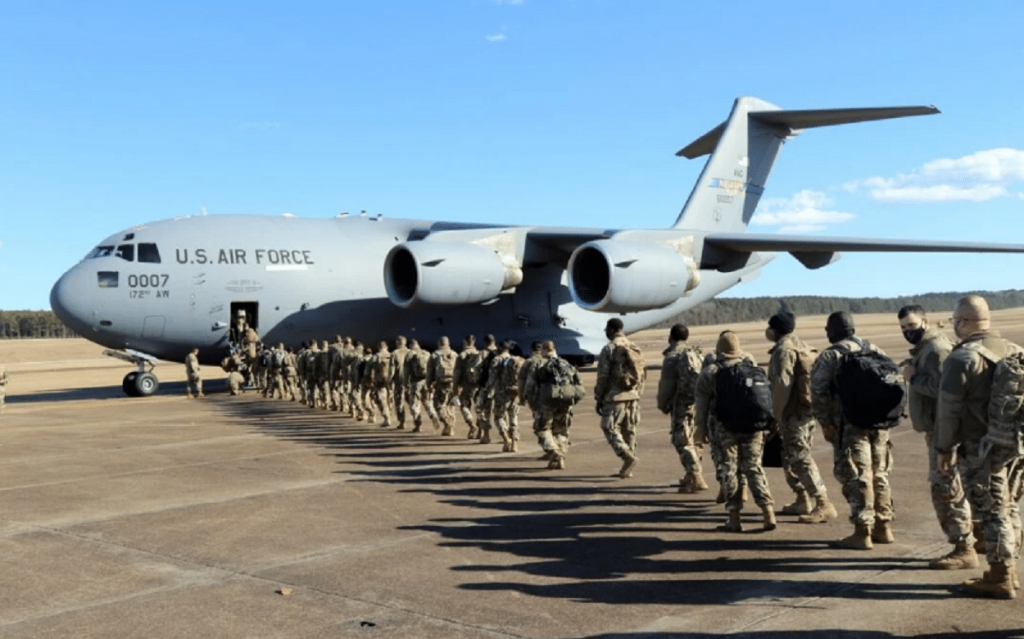 Des soldats de la garde nationale américaine montant dans un avion de trasport de troupe pour rejoindre Washington DC avant l'investiture de Joe Biden