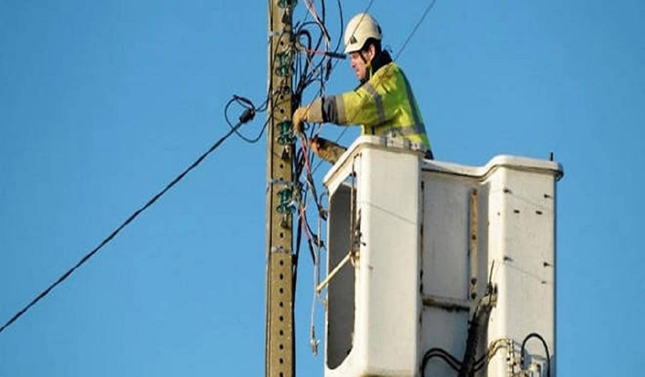 Un technicien de téléphonie sur un poteau travaillant sur une ligne téléphonique en France