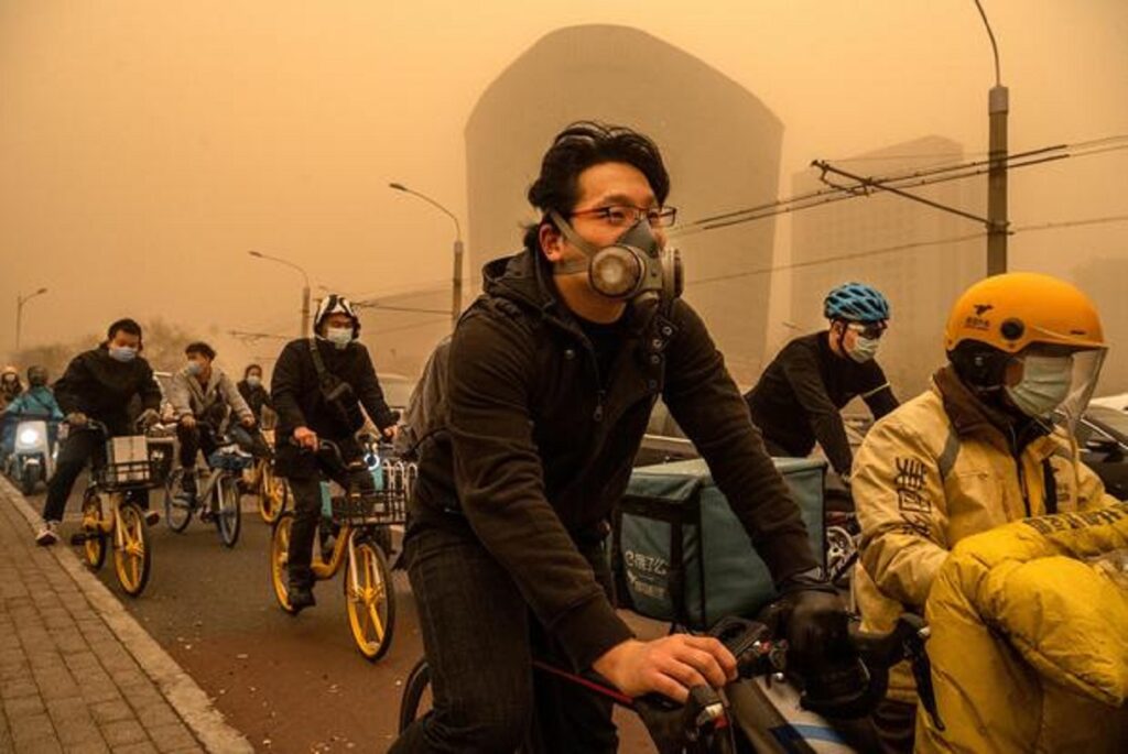 Les usagers portent des masques lorsqu'ils voyagent pendant la tempête de sable à Pékin.