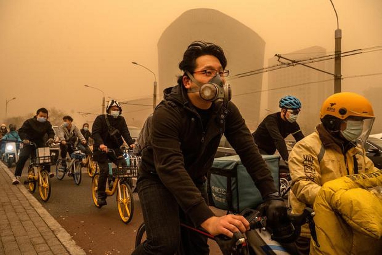 Les usagers portent des masques lorsqu'ils voyagent pendant la tempête de sable à Pékin.