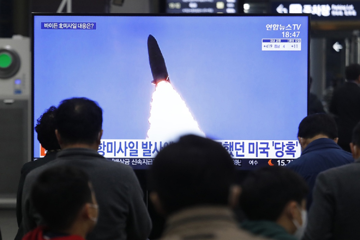 Des responsables nord-coréens regardent le tire d'un missile sur un écran